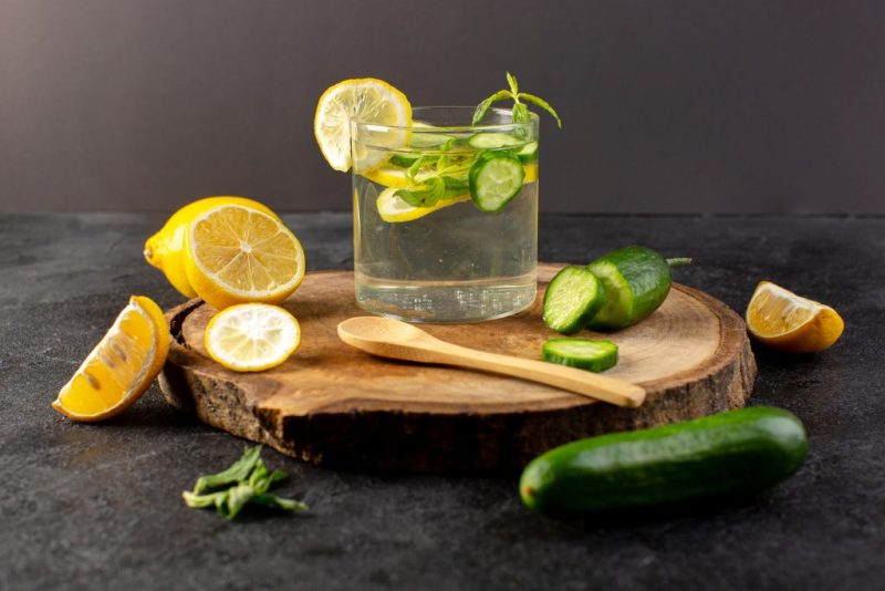 front-view-water-with-lemon-fresh-cool-drink-inside-glass-with-green-leaves-with-ice-cubes-sliced-lemons-cucumber-dark-1024x683